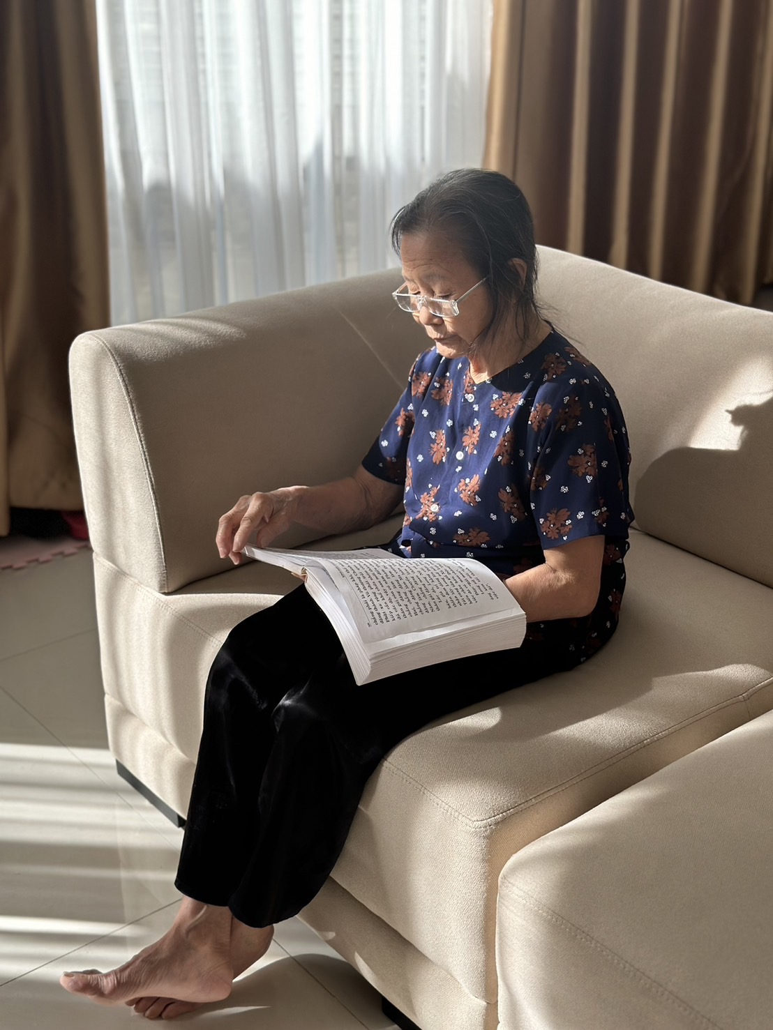 外婆靜坐翻閱佛書，深邃的眼神流露智慧與平靜。